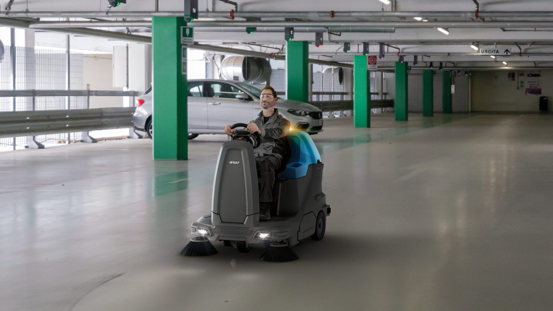 Ride-on sweeper cleaning a car park deck
