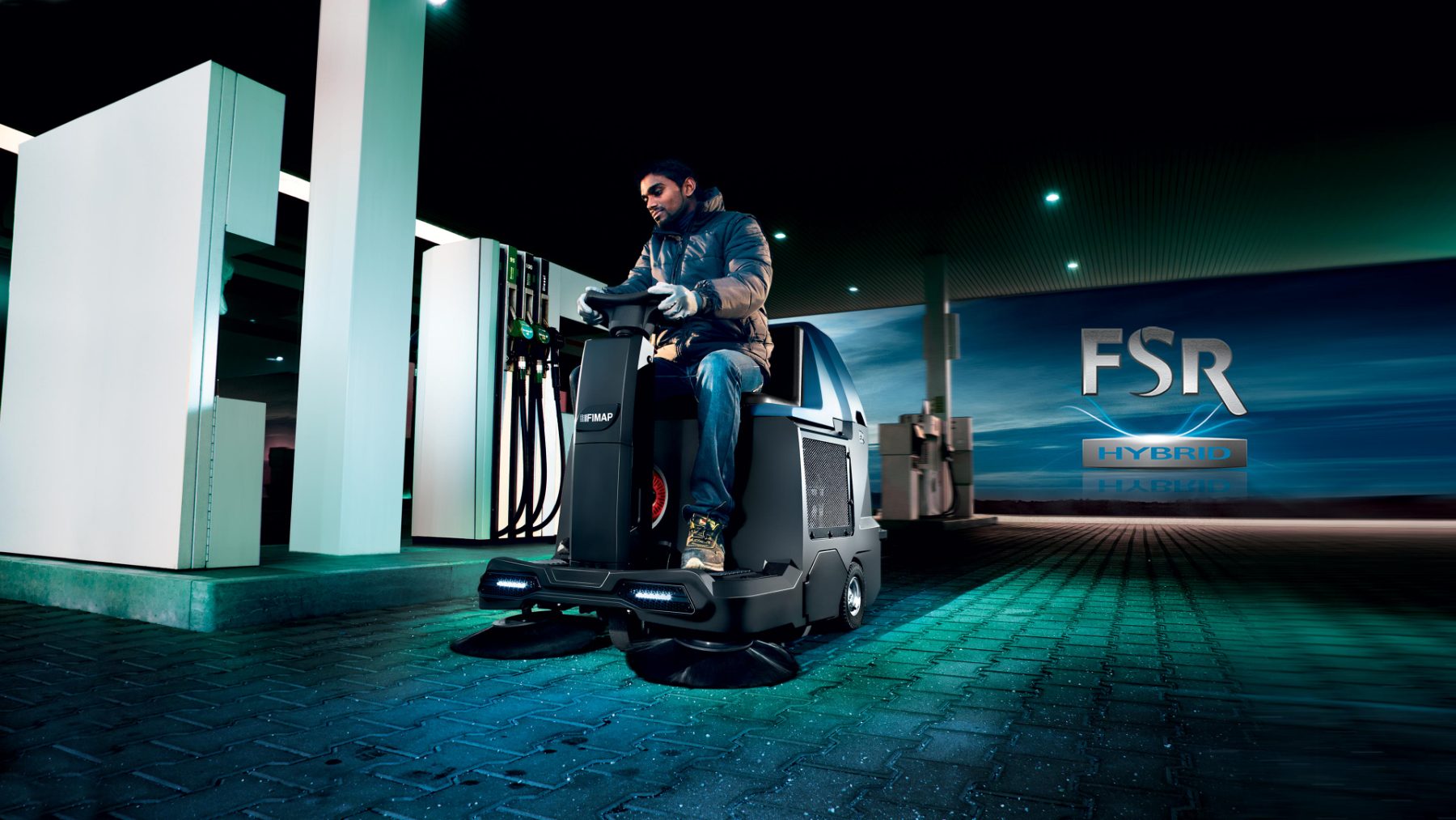 Sweeper cleaning a fuel station forecourt at night