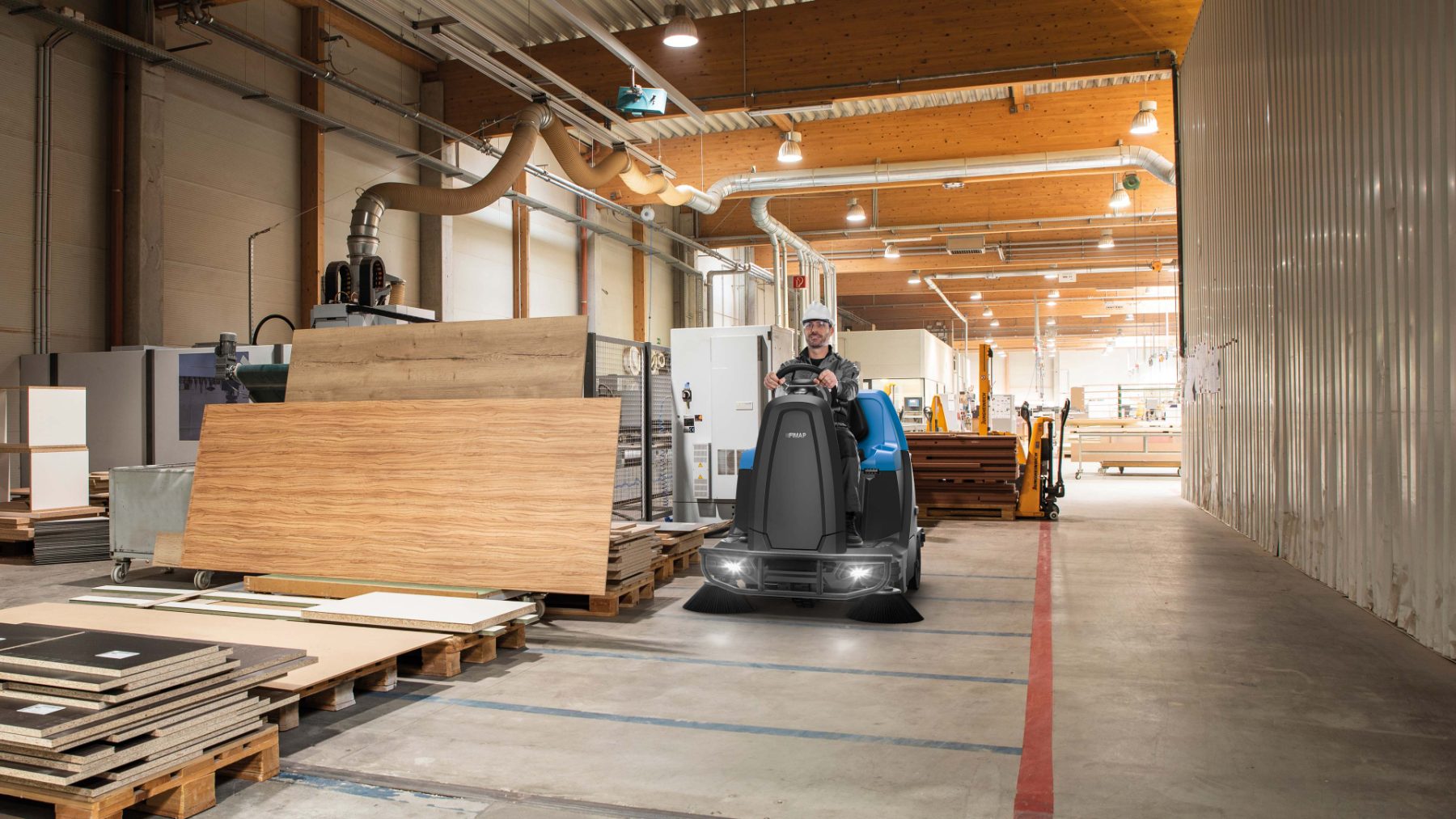 Sweeper clearing timber dust in a factory